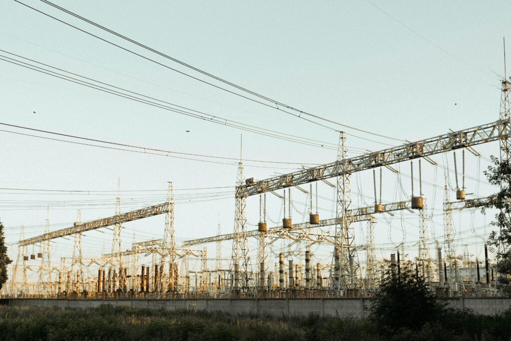 A wide view of an industrial electrical substation with power lines and towers outdoors.